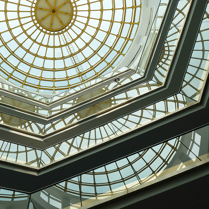 Interior view of a bright building with glass dome.